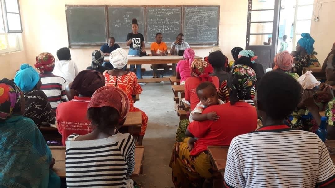 Community members seated in a classroom listening to YBSP presenters at a training workshop
