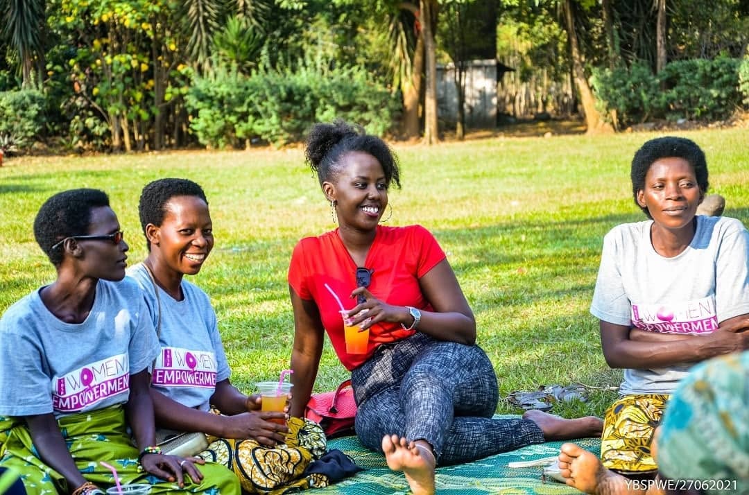 Members of a women's empowerment group chatting and laughing together outdoors