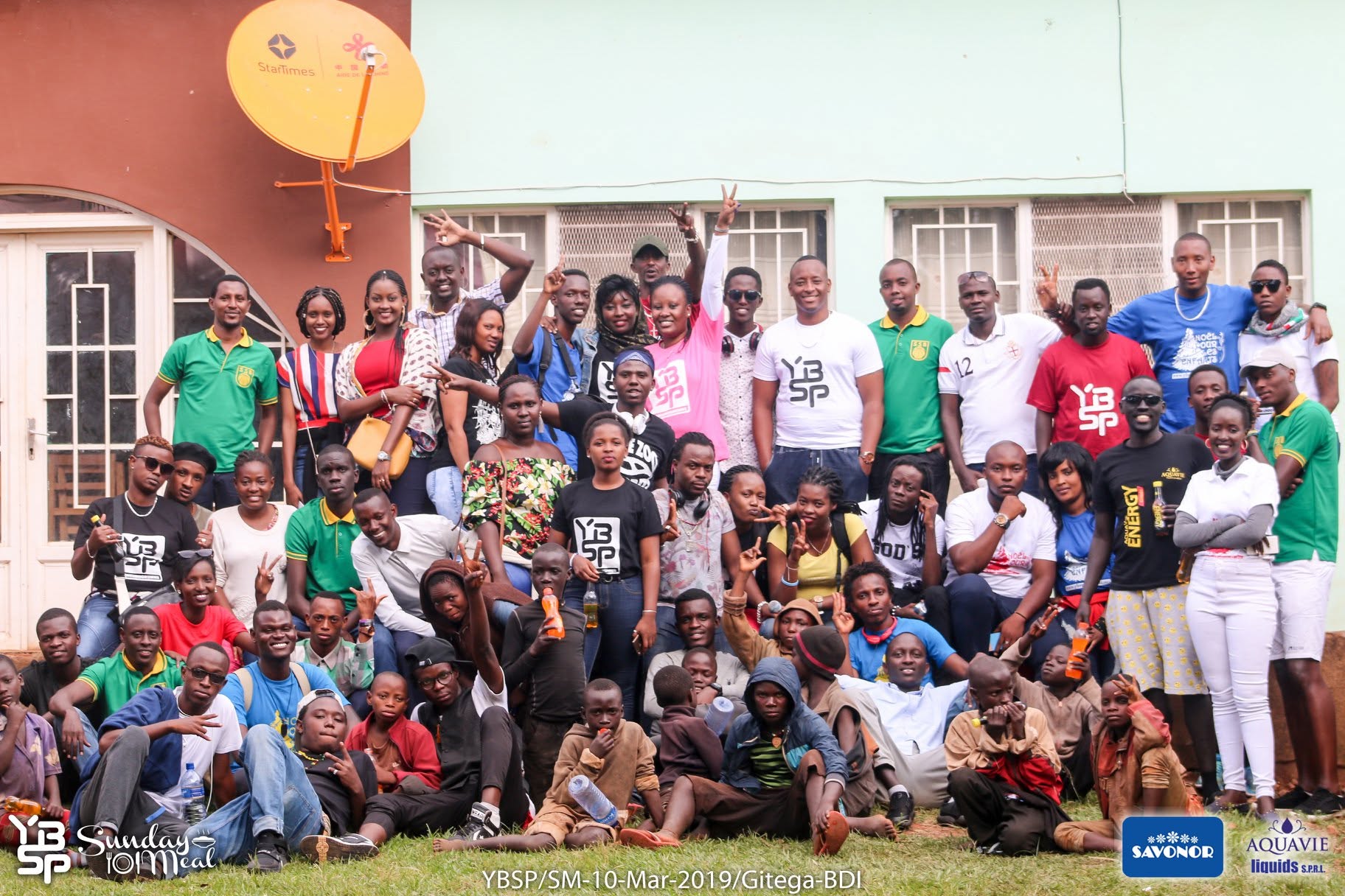Large group photo of YBSP volunteers and youth gathered outdoors in Gitega, Burundi