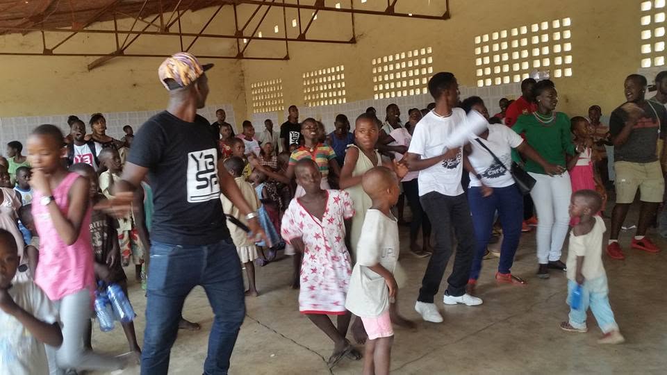 YBSP team members dancing and playing with Burundian children during an indoor community activity